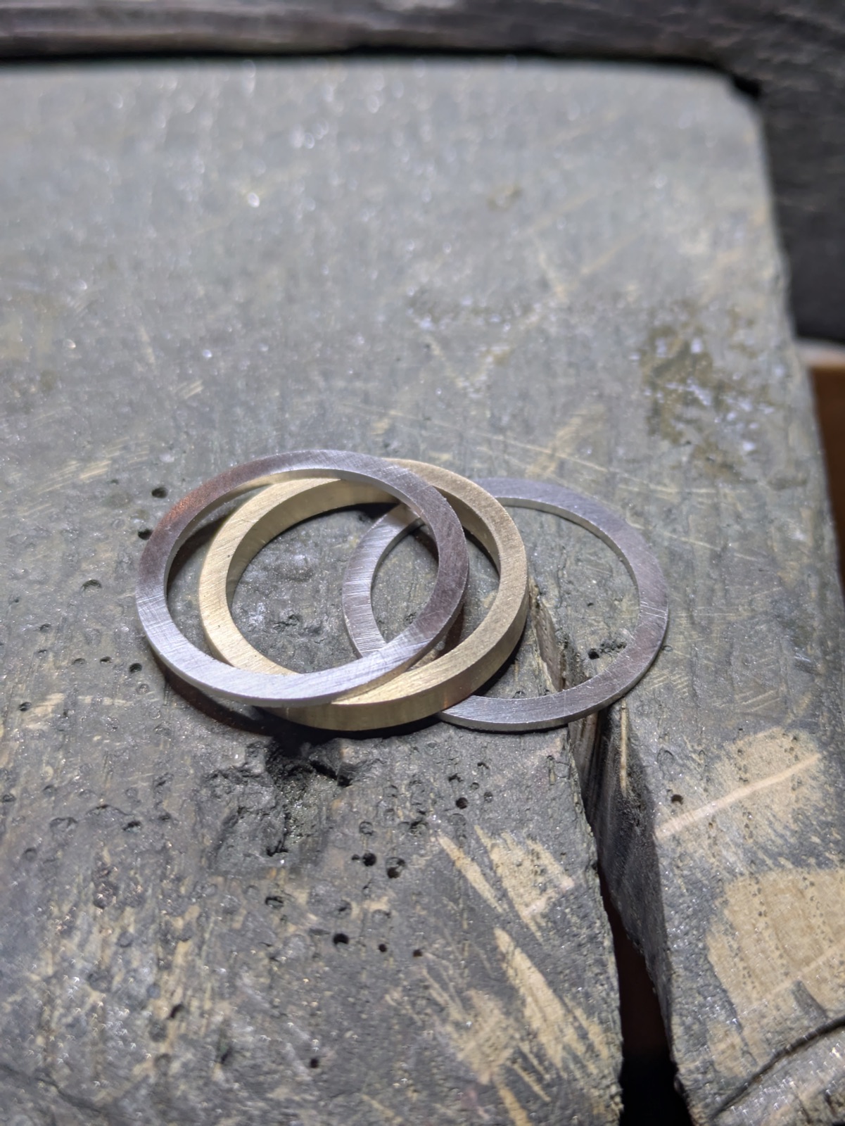 Anneaux d'alliances en or et or blanc en cours de fabrication sur l'établi