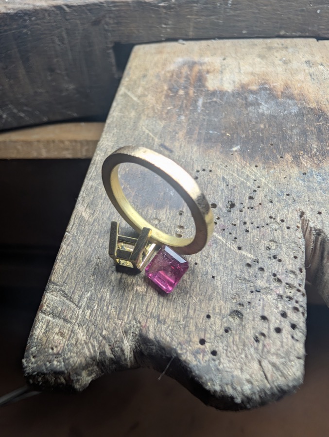 Bague en or jaune et pierre rose en cours de montage