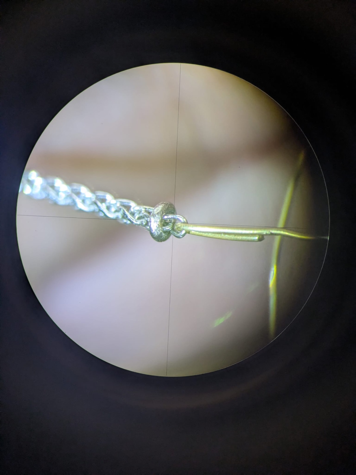 Réparation d'une chaîne observée au microscope à l'atelier